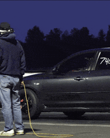 a man standing next to a car that has the number 740 on the door