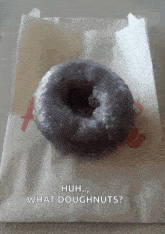 a purple donut in a paper bag with the words huh what doughnuts