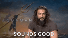 a man with a beard is holding a trident and pointing at the camera with the words `` sounds good '' .