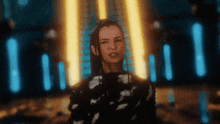 a woman in a black and white dress is standing in front of a row of neon lights .