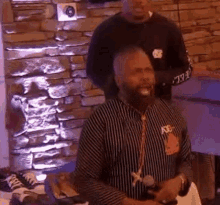 a man with a beard is sitting in front of a microphone in a room .