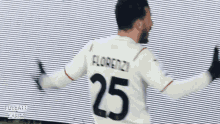 a soccer player wearing a white jersey with the number 25 on the back