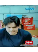 a man is sitting in front of a stack of boxes and a sign that says spg