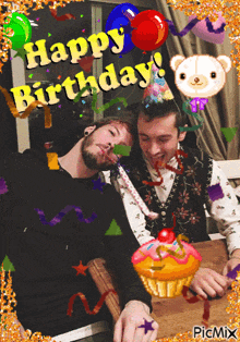 a picture of two men celebrating a birthday with a cupcake