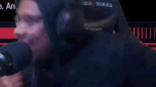 a man wearing headphones is sitting in front of a microphone and making a face .
