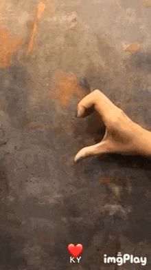 a woman 's hand is making a heart shape with her fingers