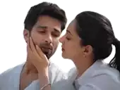 a woman is kissing a man on the cheek while holding his face .