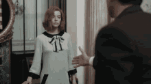 a man in a suit talks to a woman in a white and black dress