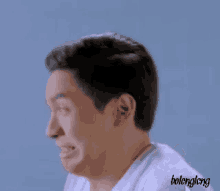 a man in a white shirt is making a funny face and the word bolengling is on the bottom of the image