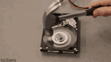 a person is hitting a hard drive with a hammer ..